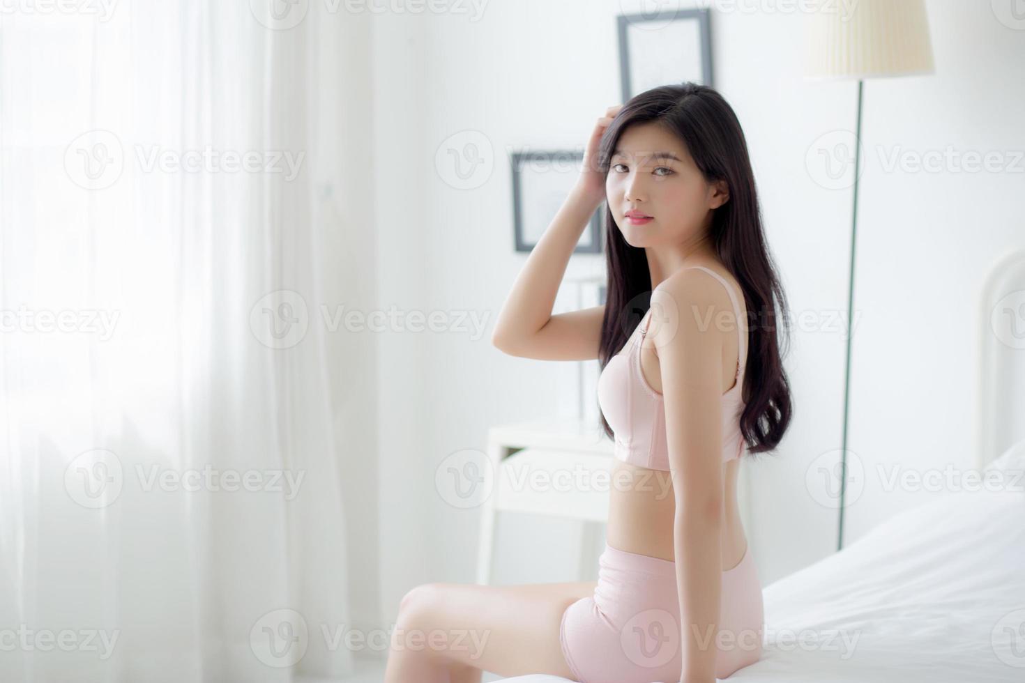 mooi portret jong Aziatisch vrouw sexy in ondergoed figuur fit kom tot rust met verleidelijk in slaapkamer, schoonheid Azië meisje lichaam slank in lingerie zelfverzekerd en gelukkig zittend in slaapkamer, levensstijl concept. foto