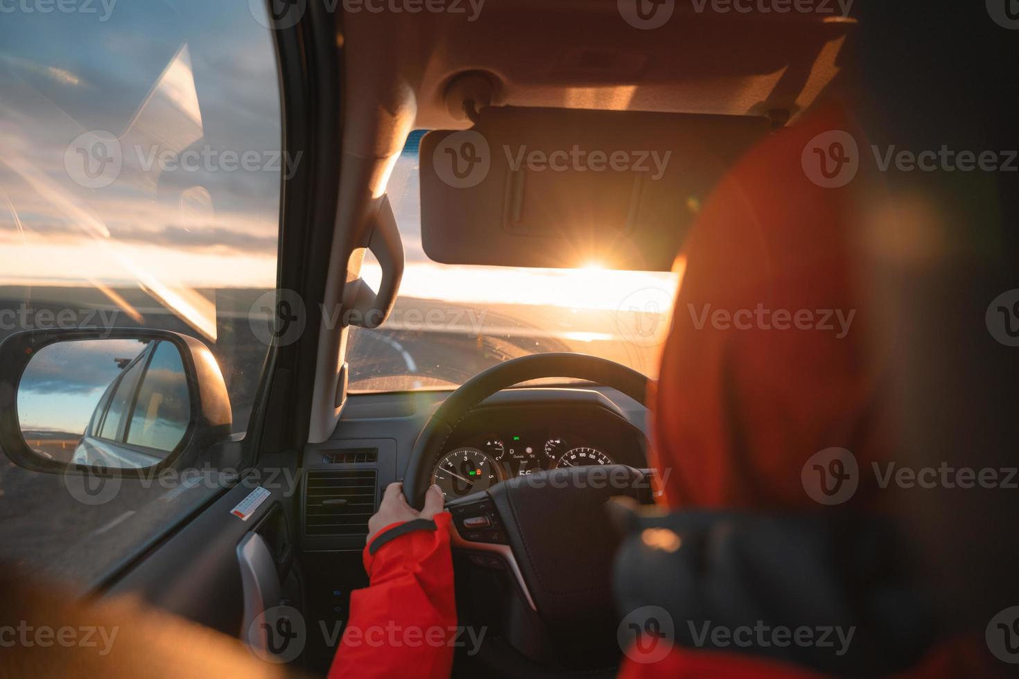 Mens het rijden een auto door wildernis Aan asfalt weg in de zonsondergang foto