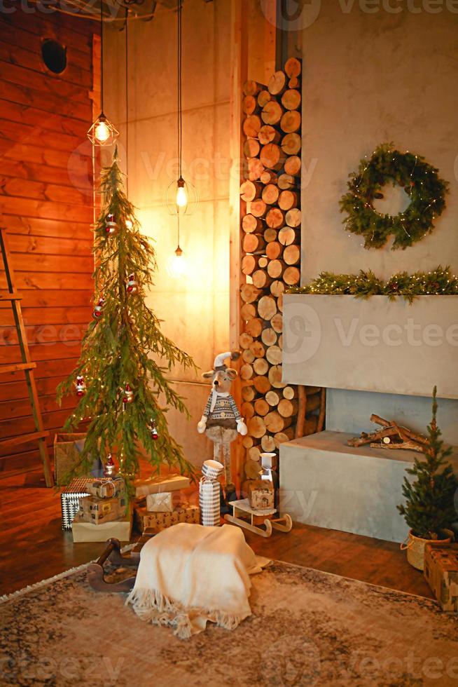 Kerstmis interieur in de stijl van een Scandinavisch zolder grijs concreet, houten decor, gloeiend lampen, realistisch kunstmatig Kerstmis boom. knus nieuw jaar in een land huis foto