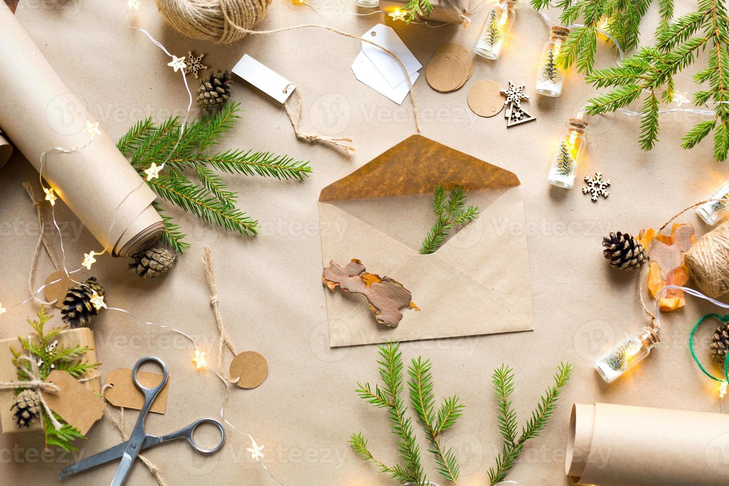 envelop met felicitaties voor Kerstmis en Nieuwjaar in milieuvriendelijke materialen kraftpapier, levende dennentakken, kegels, touw. tags mock-up, natuurlijk decor, met de hand gemaakt. brief voor de kerstman. botweg foto