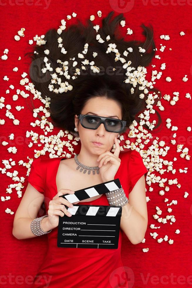 verbaasd meisje met 3D-bioscoop bril, popcorn en regisseur dakspaan foto