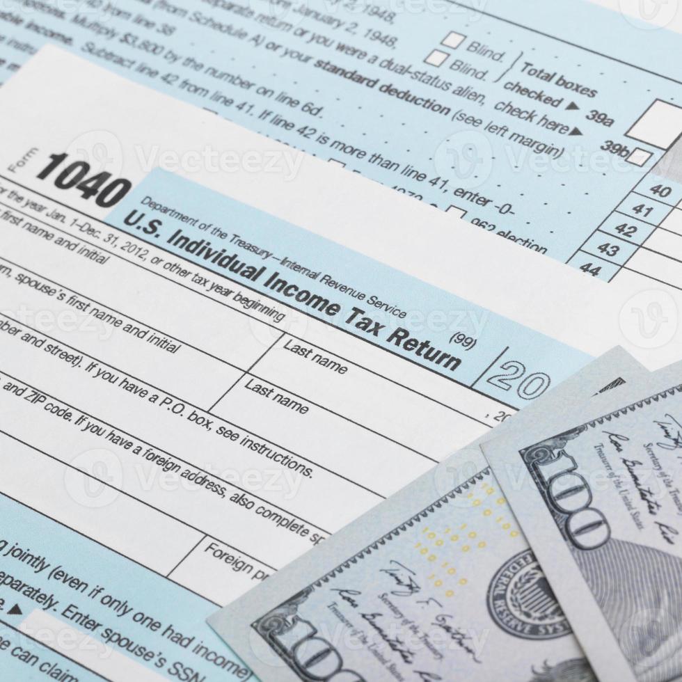 VS belasting 1040 formulier en 100 Amerikaanse dollarbiljetten foto