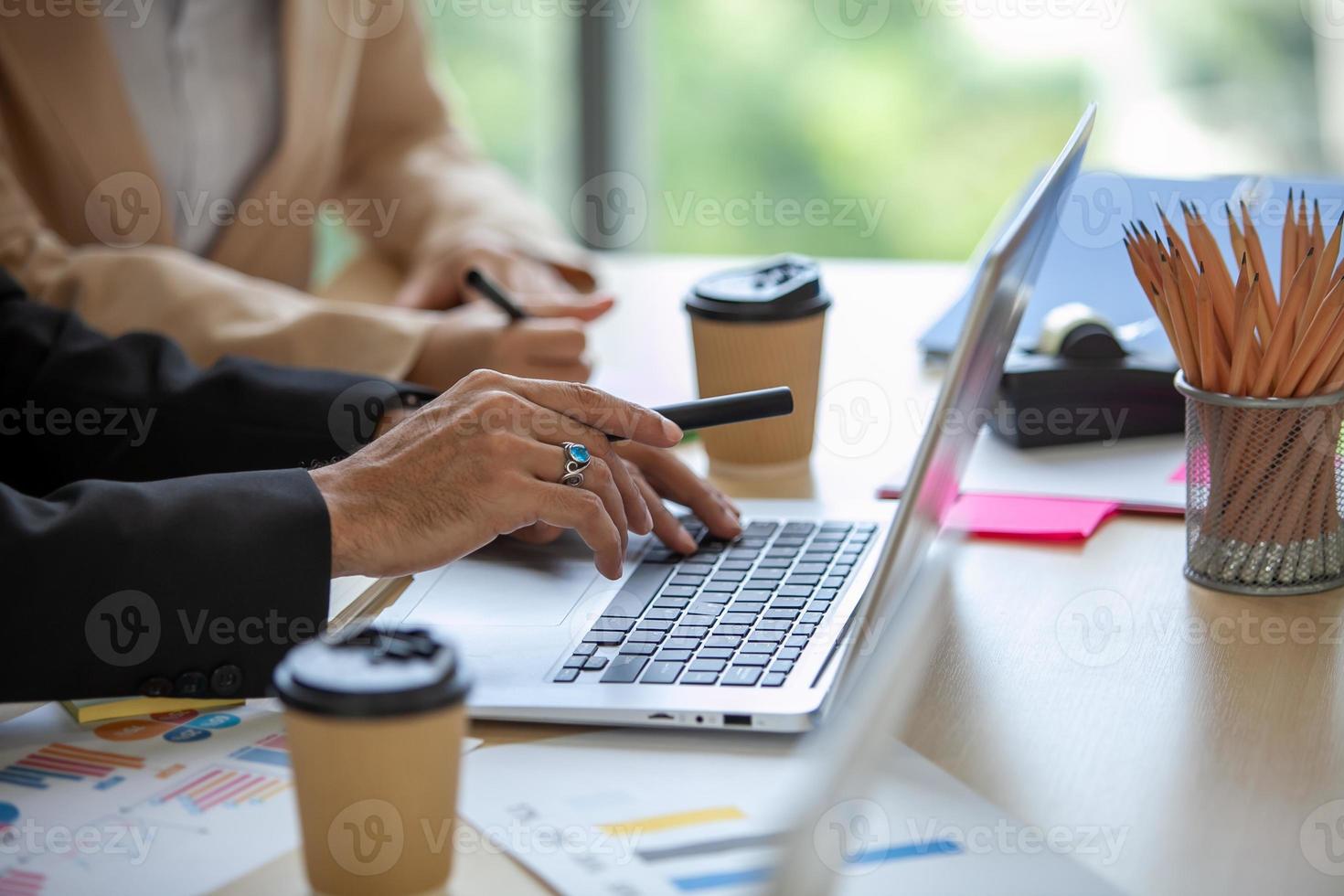 Gesloten omhoog van bedrijf team mannetje en vrouw collega's pratend Bij werk delen ideeën met laptop, gelukkig collega's werk samen Aan computer in kantoor. foto