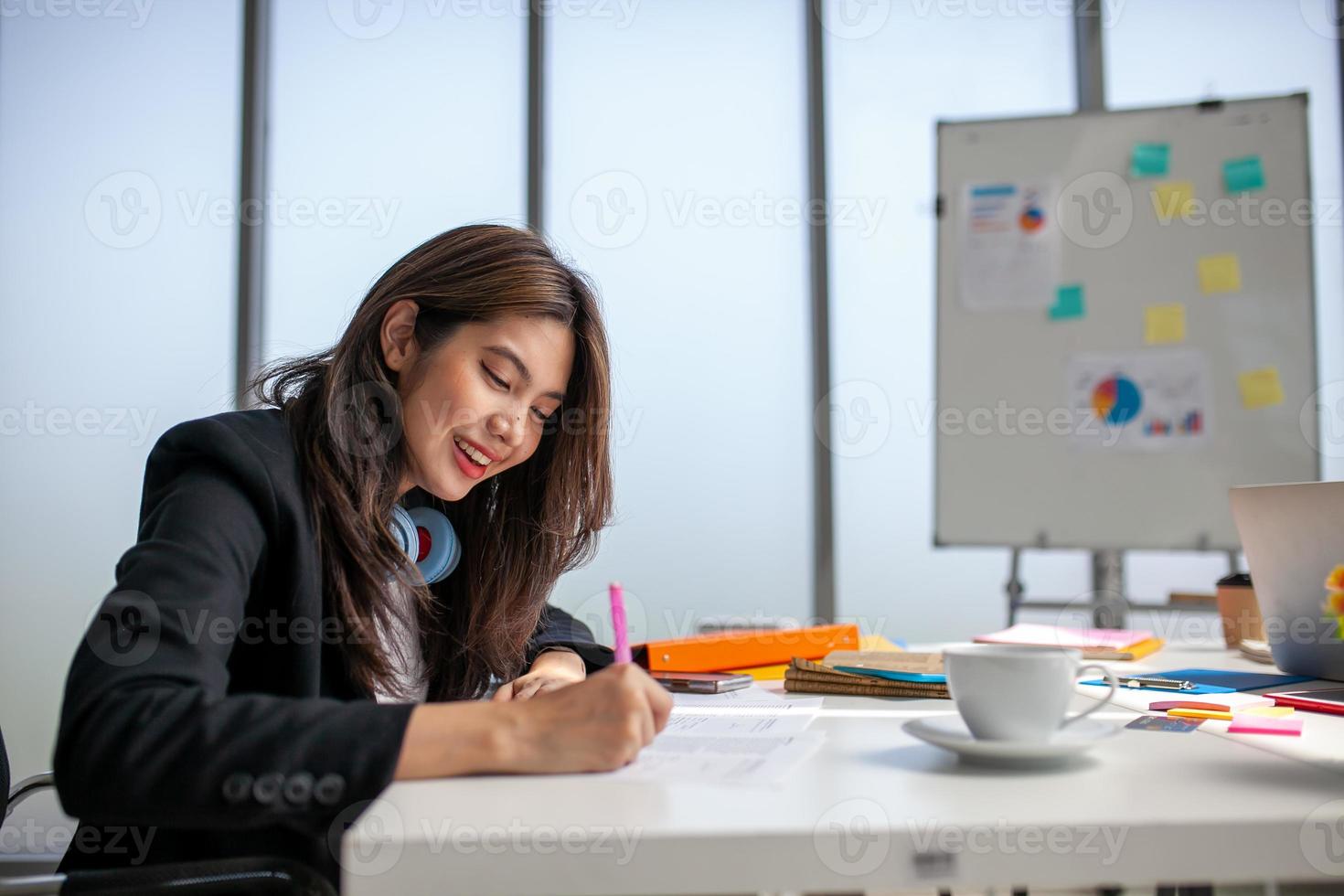 portret van Aziatisch mooi bedrijf vrouw werken Bij de kantoor, schrijven een document Aan tafel. foto