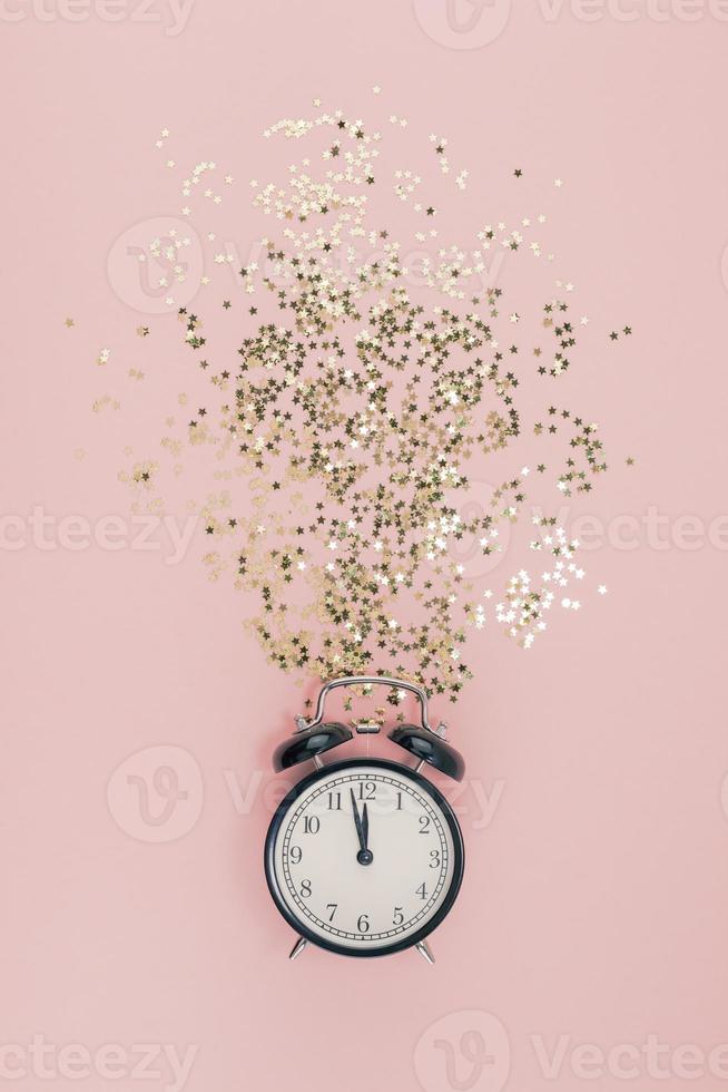 nieuw jaar concept. alarm klok met gouden confetti foto