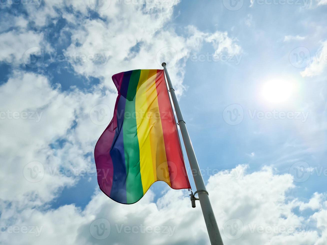 regenboog trots vlag illustratie. lgbt gemeenschap symbool in regenboog kleuren tegen de blauw lucht . foto