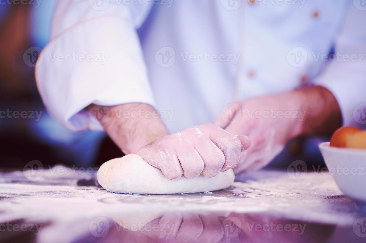 chef handen voorbereidingen treffen deeg voor pizza foto