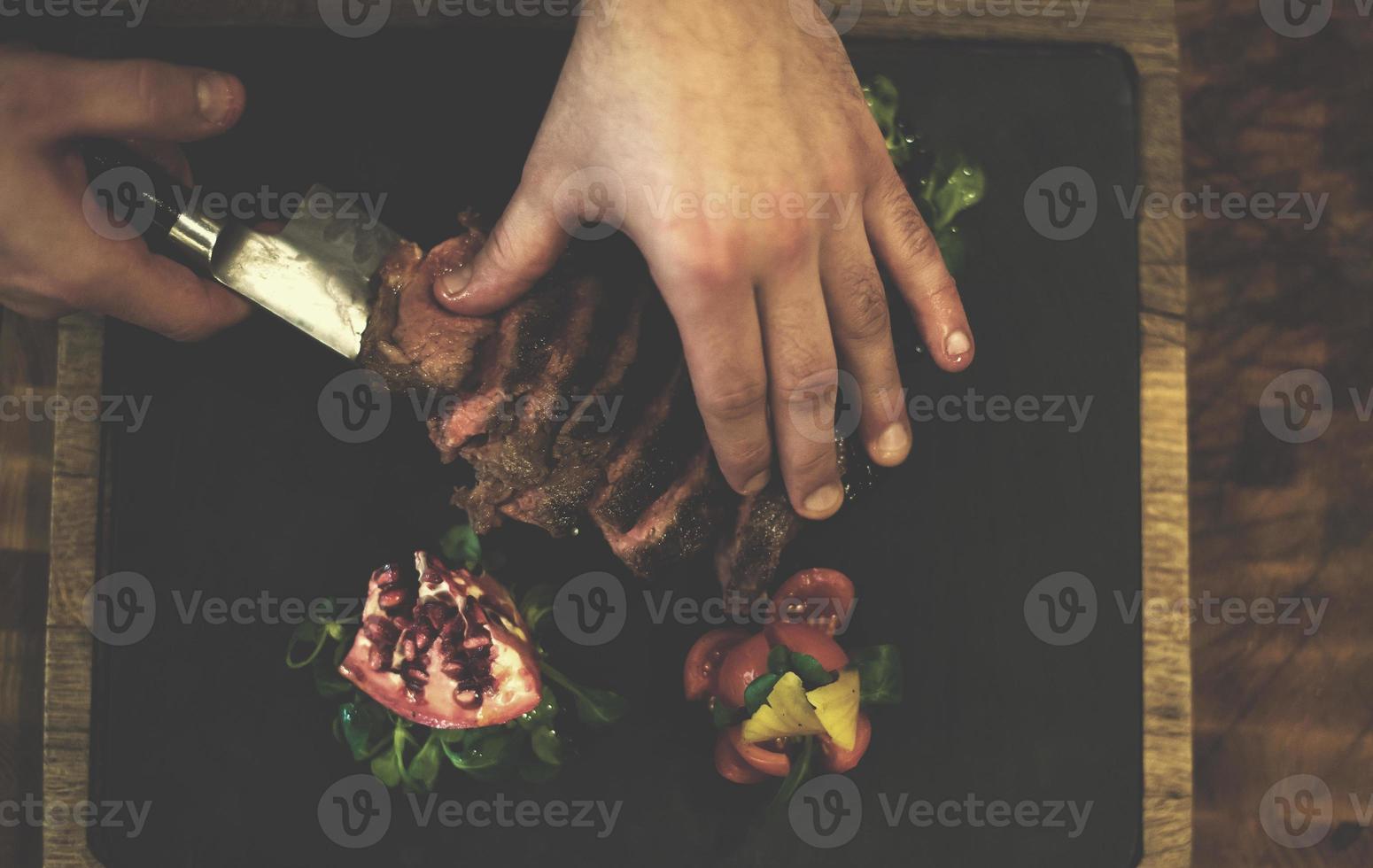 top visie van chef handen portie rundvlees steak foto