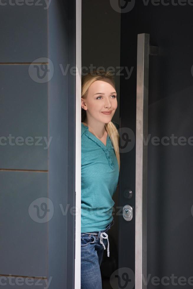 vrouw opening haar huis deur foto