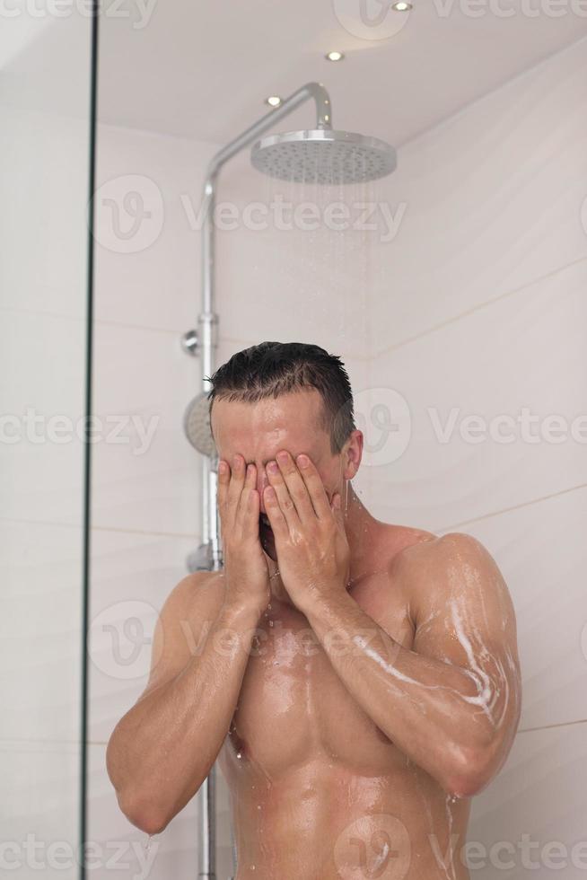 Mens nemen douche in bad foto