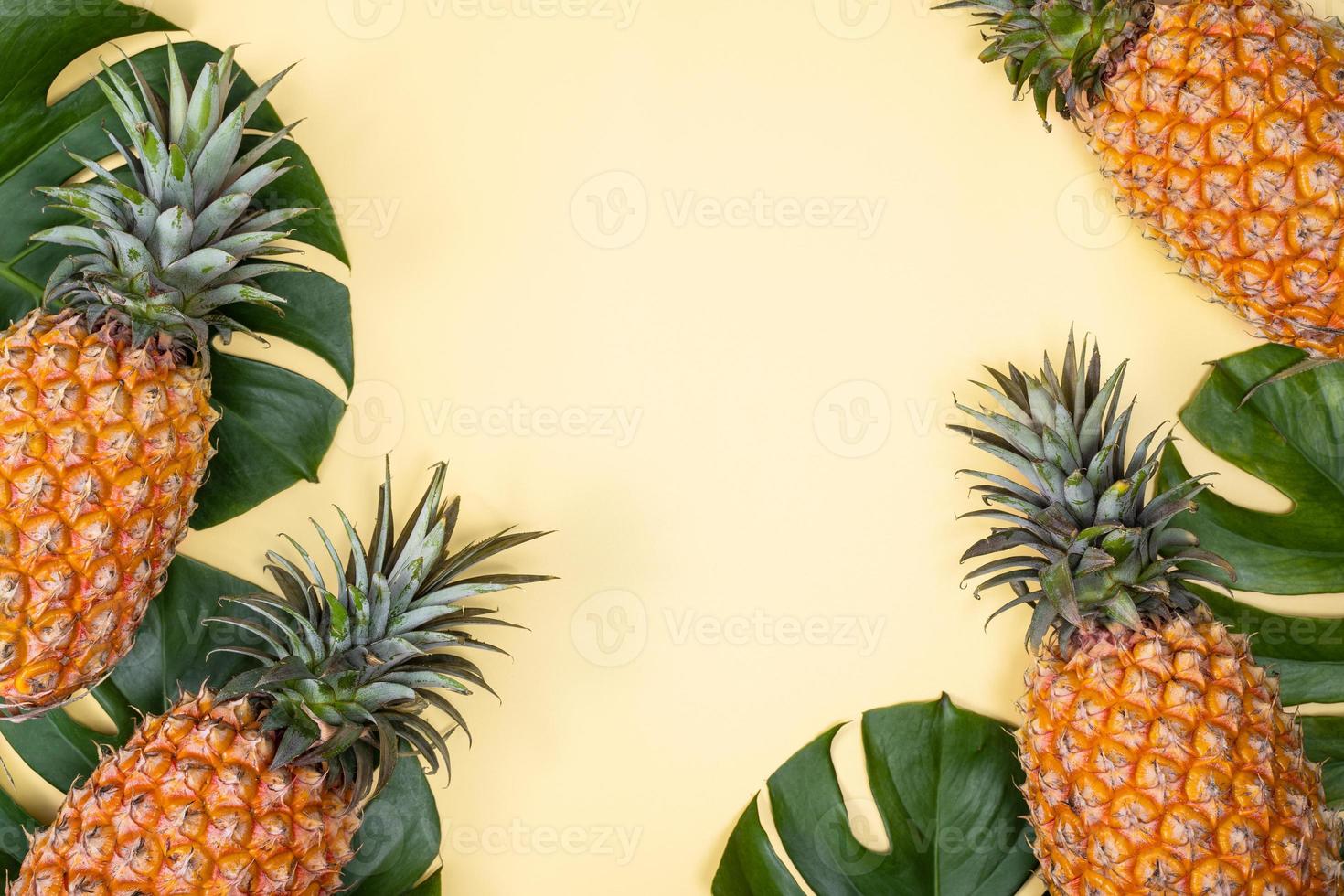 mooie ananas op tropische palm monstera bladeren geïsoleerd op heldere pastel gele achtergrond, bovenaanzicht, plat lag, overhead boven zomerfruit. foto