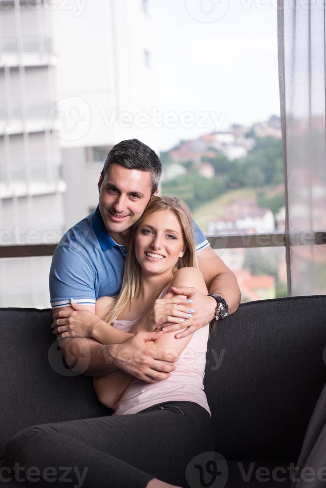 jong knap paar knuffelen Aan de sofa foto