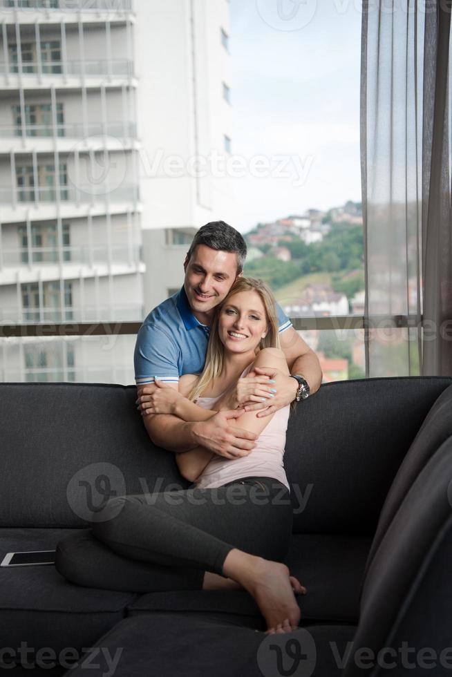 jong knap paar knuffelen Aan de sofa foto