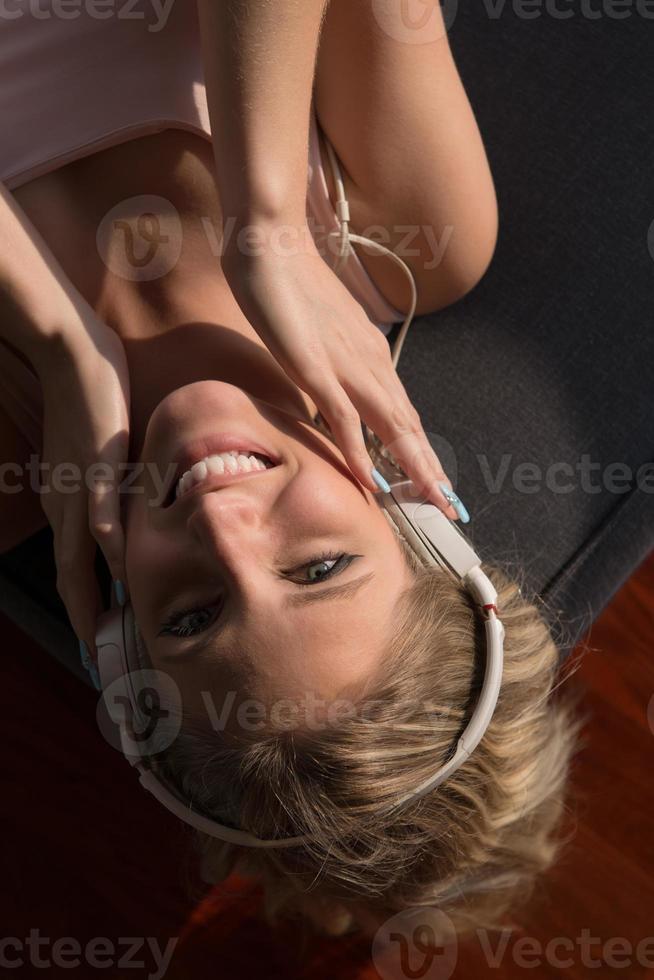 lief blond vrouw luisteren naar muziek- terwijl resting Aan bankstel foto