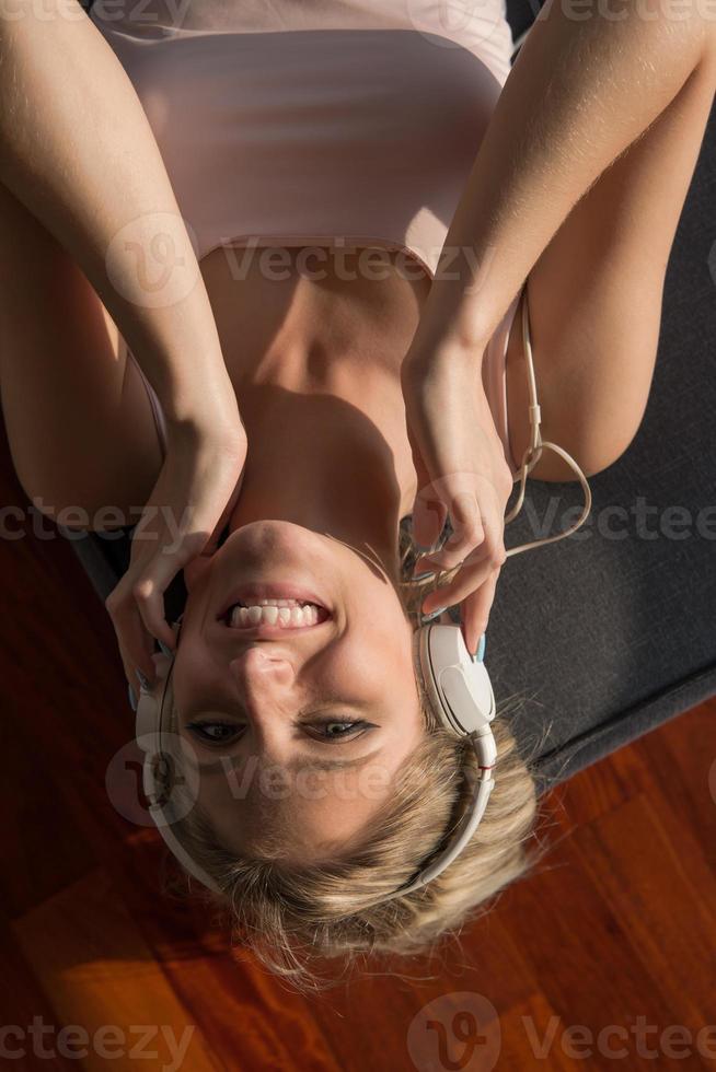lief blond vrouw luisteren naar muziek- terwijl resting Aan bankstel foto