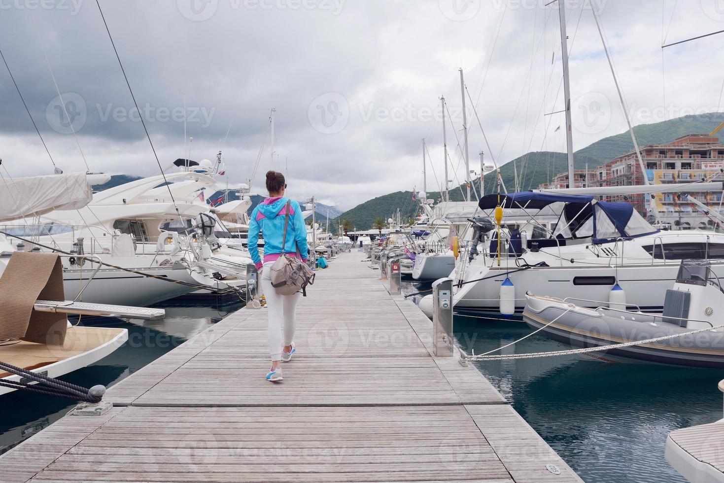 ontspannen jong vrouw wandelen in jachthaven foto