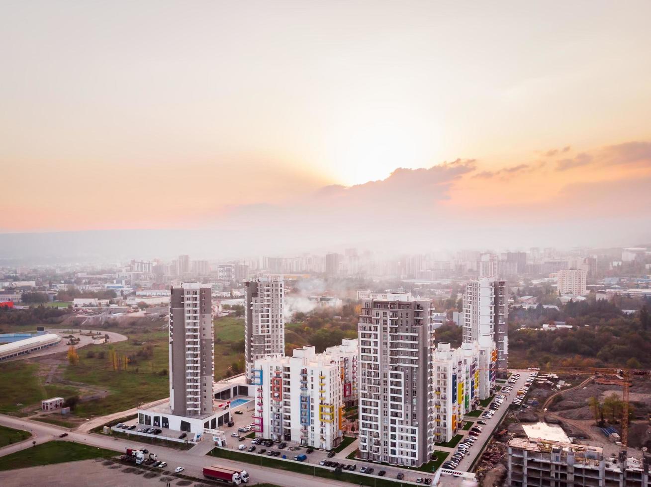 tbilisi, Georgië , 2021 - antenne visie diamant appartement complex hoog echt landgoed gebouwen complex in stad buitenwijken met vervuild vaag lucht en zonsondergang achtergrond foto