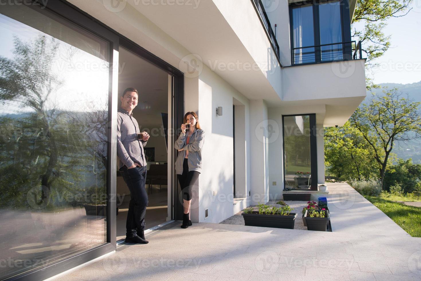 paar genieten van Aan de deur van hun luxe huis villa foto