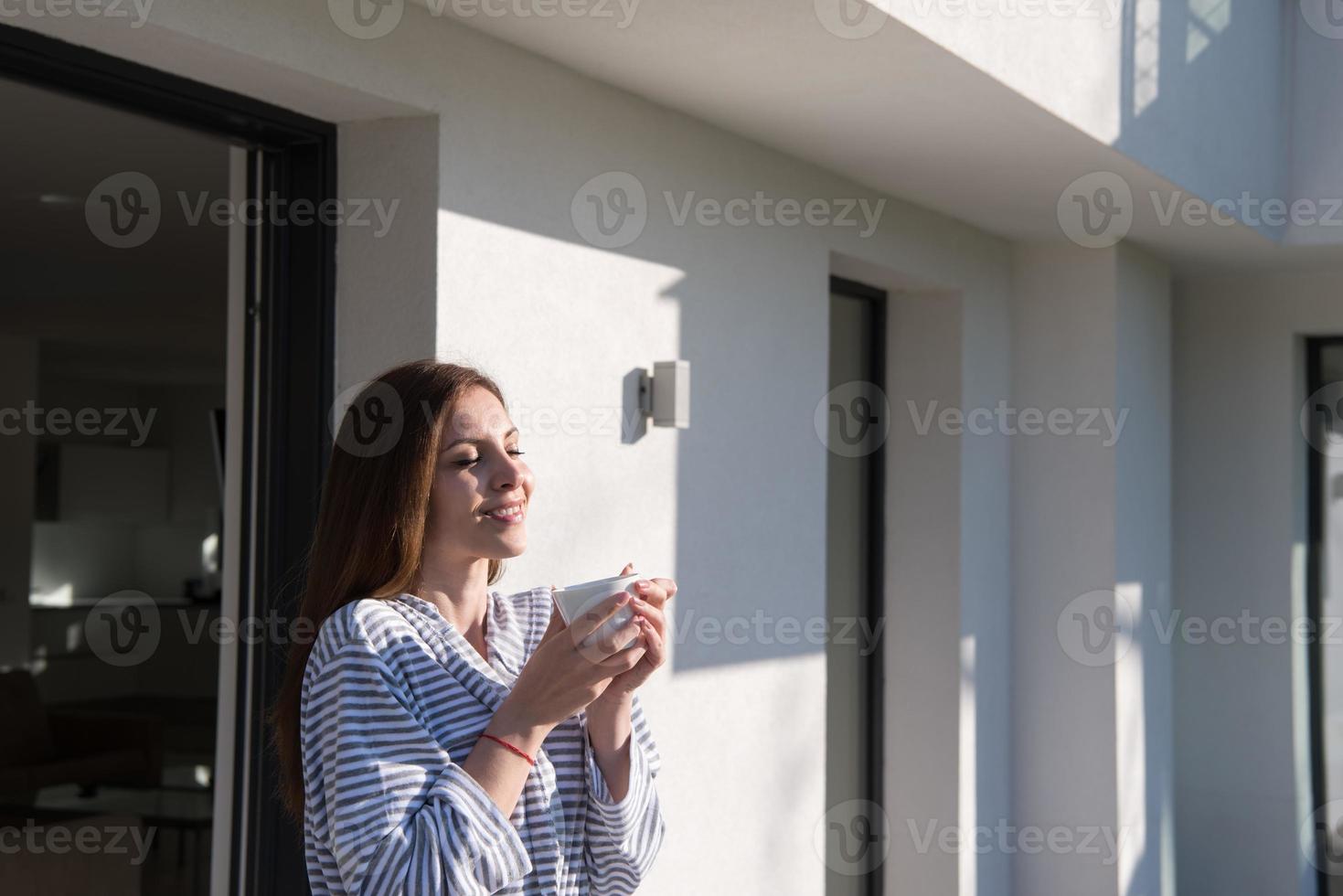 vrouw in een badjas genieten van ochtend- koffie foto