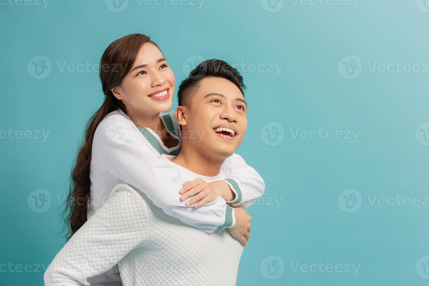 gelukkig Mens draag- zijn vriendin Aan de terug Aan blauw achtergrond foto