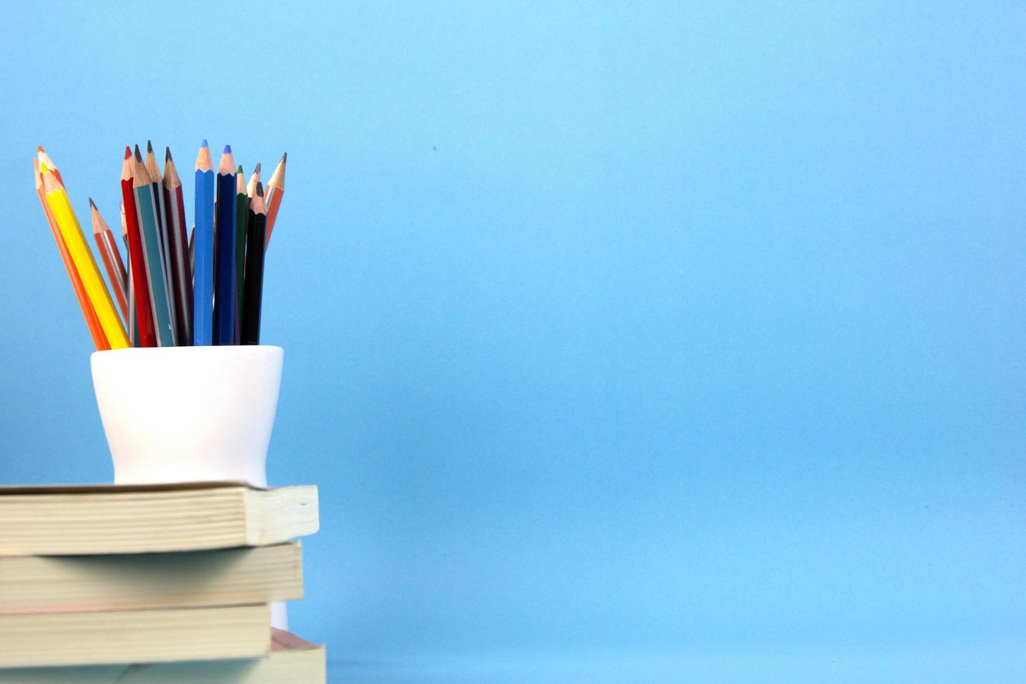 de geïsoleerd onderwijs elementen boeken, pennen, potloden Aan licht blauw achtergrond. gebruikt in terug naar school- poster, brochure sjabloon ontwerp foto