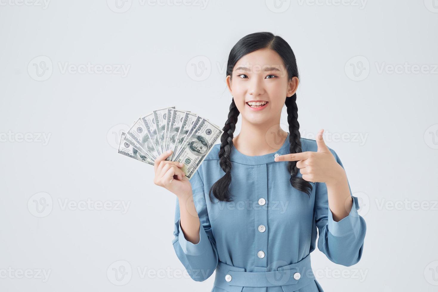 portret van gelukkig vrouw Holding en richten vinger ventilator van geld geïsoleerd over- wit achtergrond foto