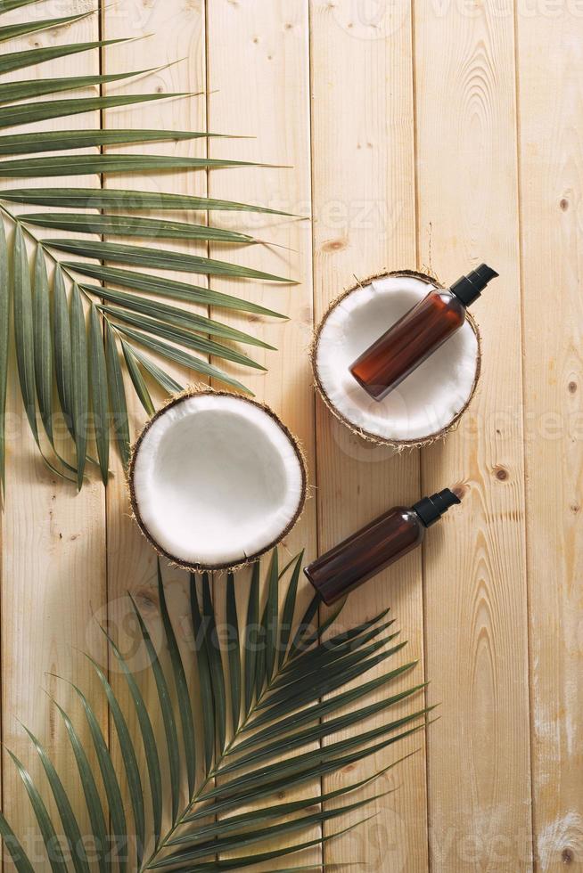 tropisch blad, zorg schoonheidsmiddelen en kokosnoot Aan een houten tafel. top visie. middelen voor haar, lichaam, huid. flatlay foto