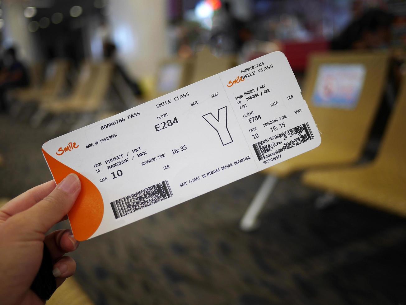 een hand- Holding huiselijk vlucht instappen voorbij gaan aan met wazig luchthaven terminal achtergrond foto