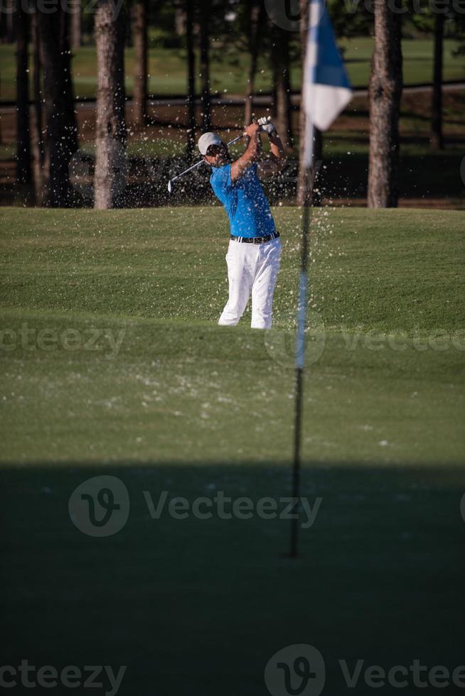 pro golfspeler raken een zand bunker schot foto