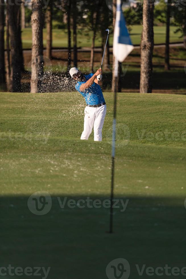 pro golfspeler raken een zand bunker schot foto