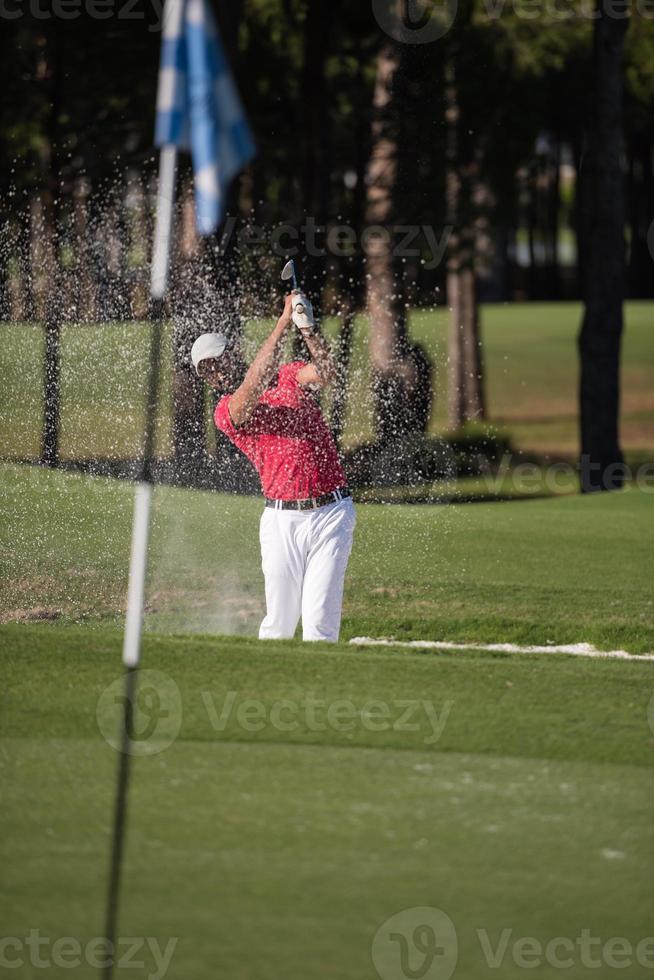 golfspeler raken een zand bunker schot foto