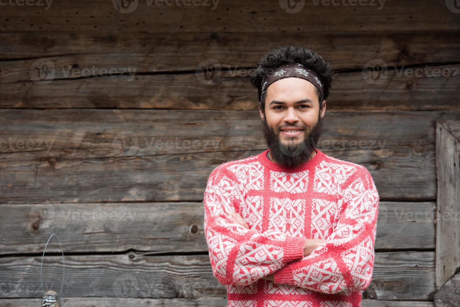 portret van jong hipster in voorkant van houten huis foto