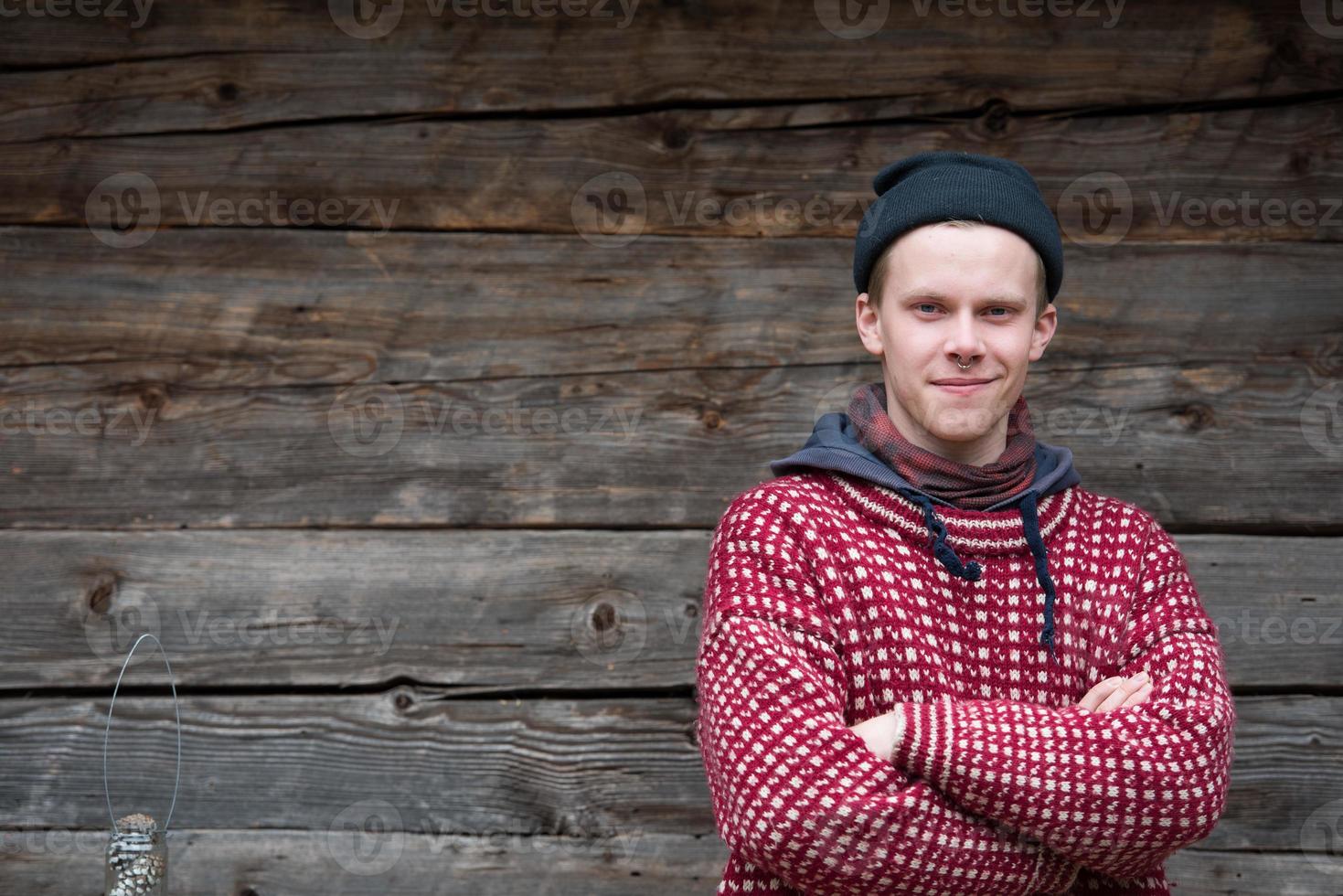 jong hipster in voorkant van houten huis foto