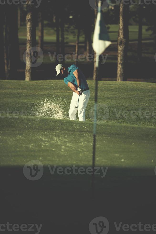 pro golfspeler raken een zand bunker schot foto