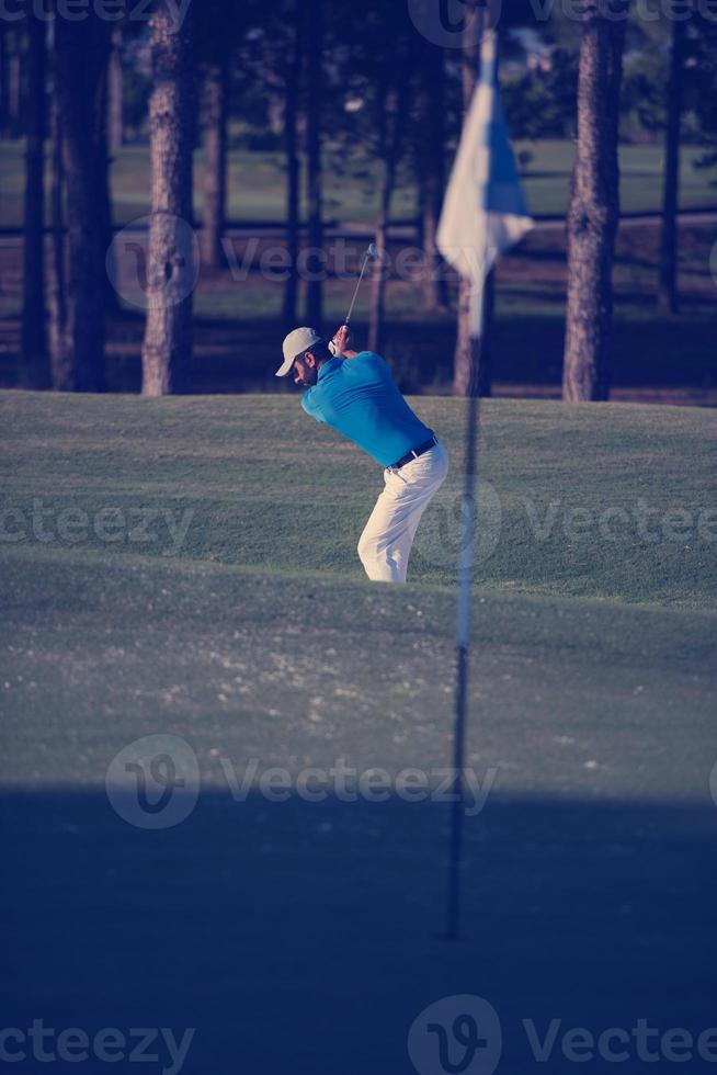 pro golfspeler raken een zand bunker schot foto