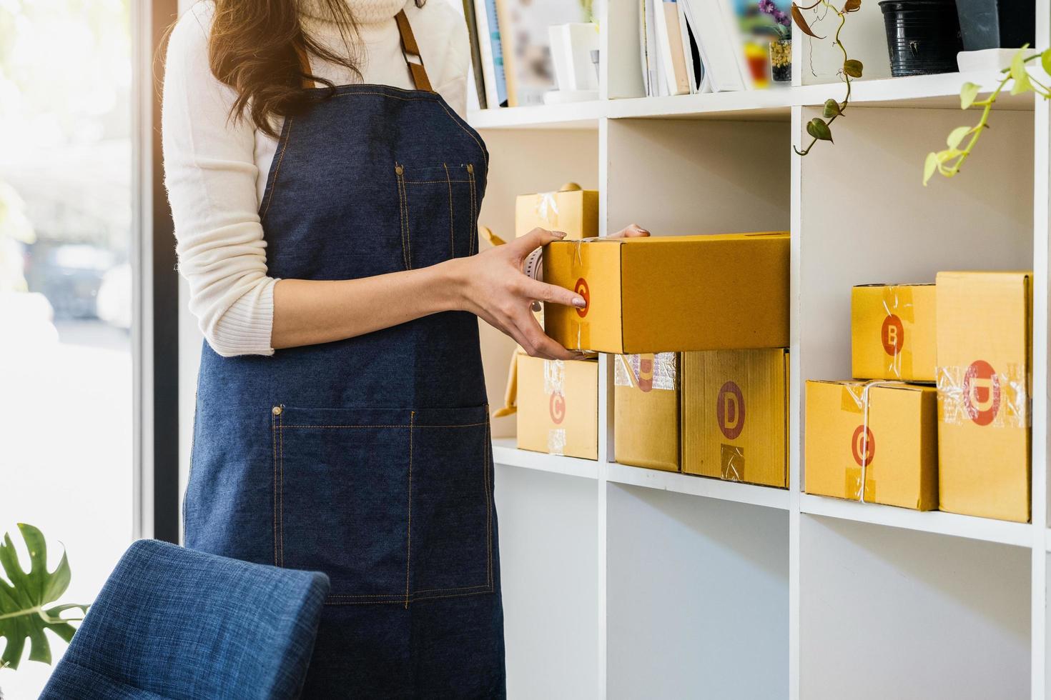 werk van huis. gelukkig Dames verkoop producten online opstarten klein bedrijf eigenaren zijn plukken omhoog pakket dozen naar pak klant bestellingen en bereiden hen voor port. foto