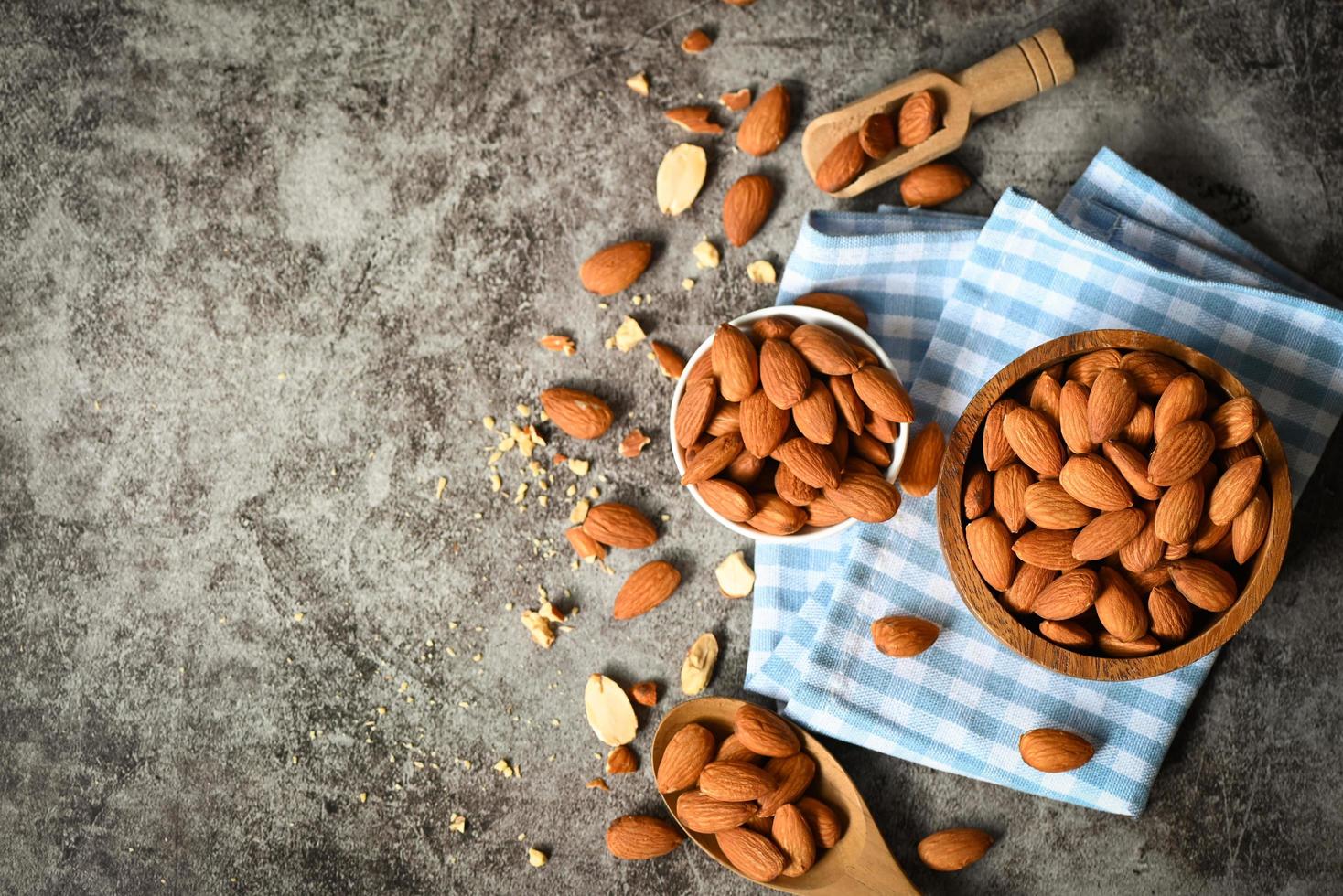 amandelen noten Aan houten kom en donker achtergrond, heerlijk zoet amandelen Aan de tafel, geroosterd amandel noot voor gezond voedsel en tussendoortje foto