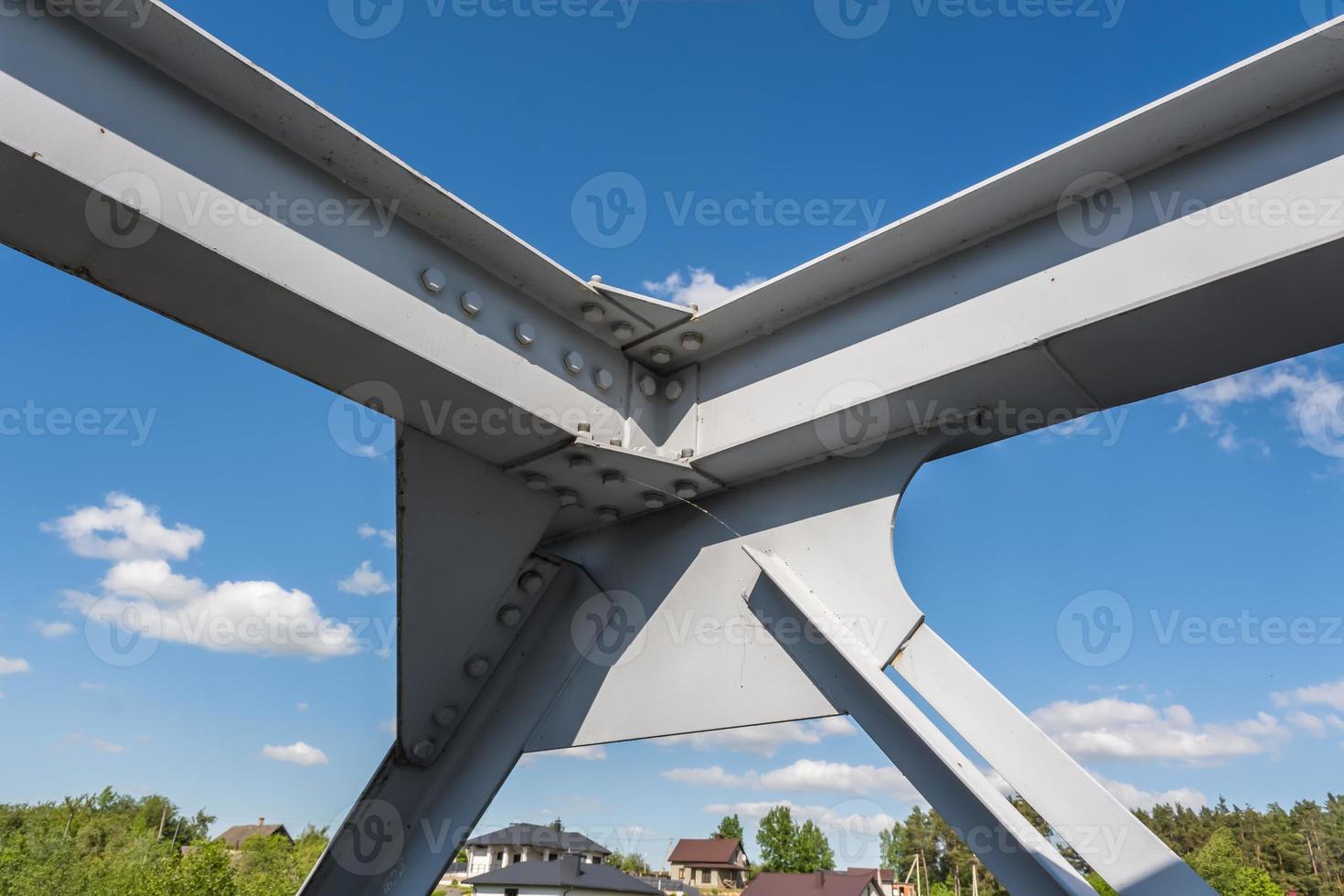 ijzer staal kader bouw van brug Aan blauw lucht achtergrond. brug metaal structuren, lijsten, bouten en noten foto