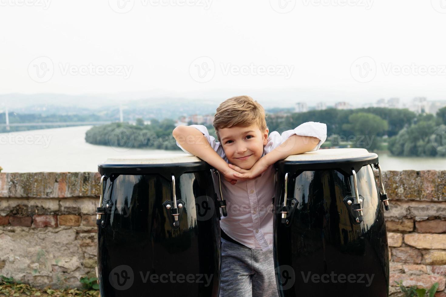 schattig kind met bongo's Bij rivieroever. foto