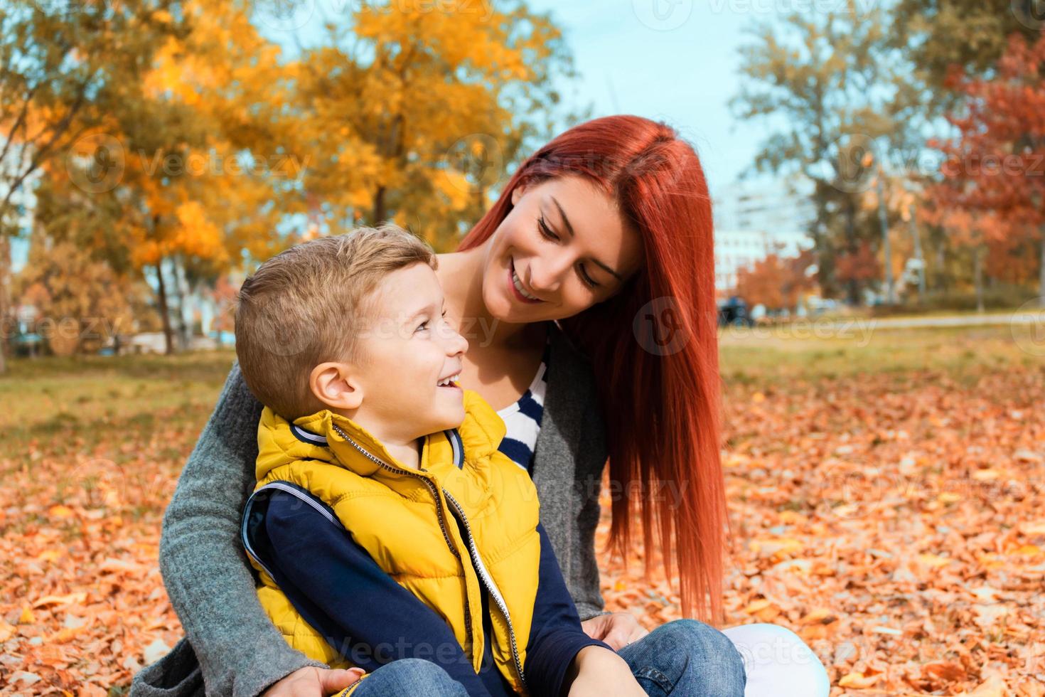 gelukkig moeder en zoon pratend terwijl genieten van in herfst dag. foto