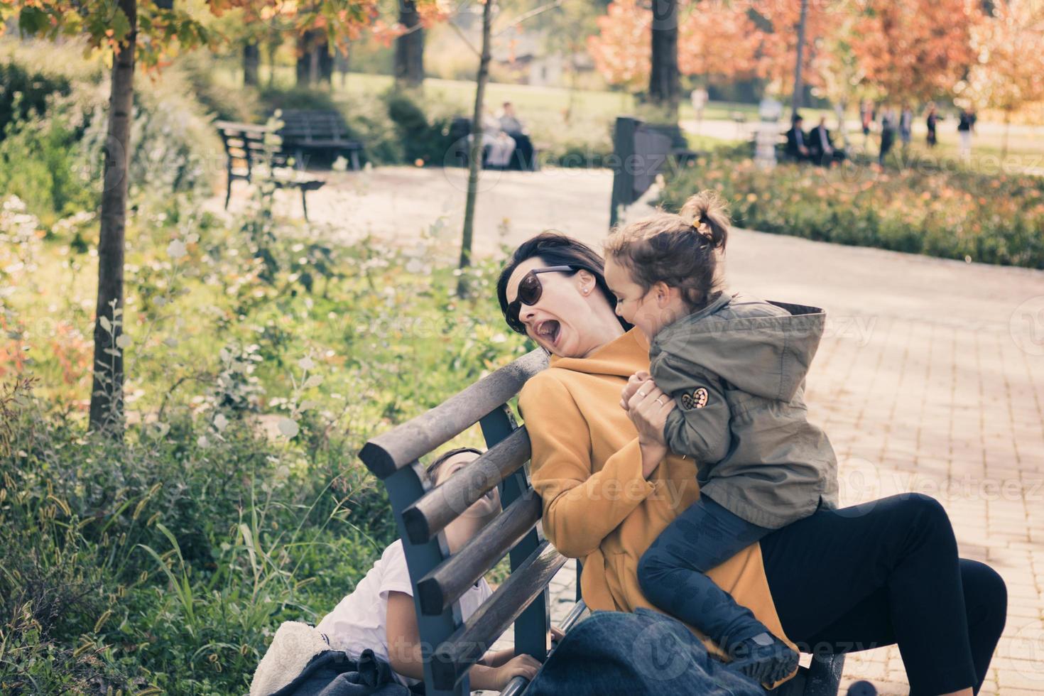 speels kinderen en hun moeder hebben pret in de park. foto