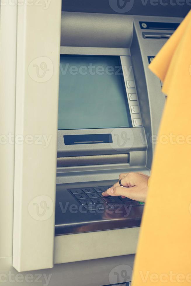 typen pin code Aan Geldautomaat machine. foto