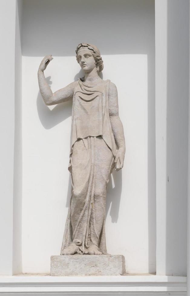 oud beeldhouwwerk van vrouw godin in voorkant van klassiek stijl huis. vrouw standbeeld in een Europese tuin foto