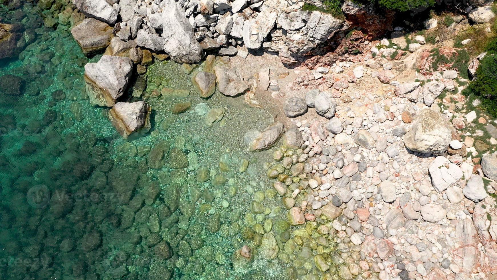 drone-uitzichten vanuit de lucht over een rotsachtige kustlijn, kristalhelder Egeïsch zeewater, toeristische stranden en veel groen op het eiland Skopelos, Griekenland. een typisch beeld van veel vergelijkbare Griekse eilanden. foto