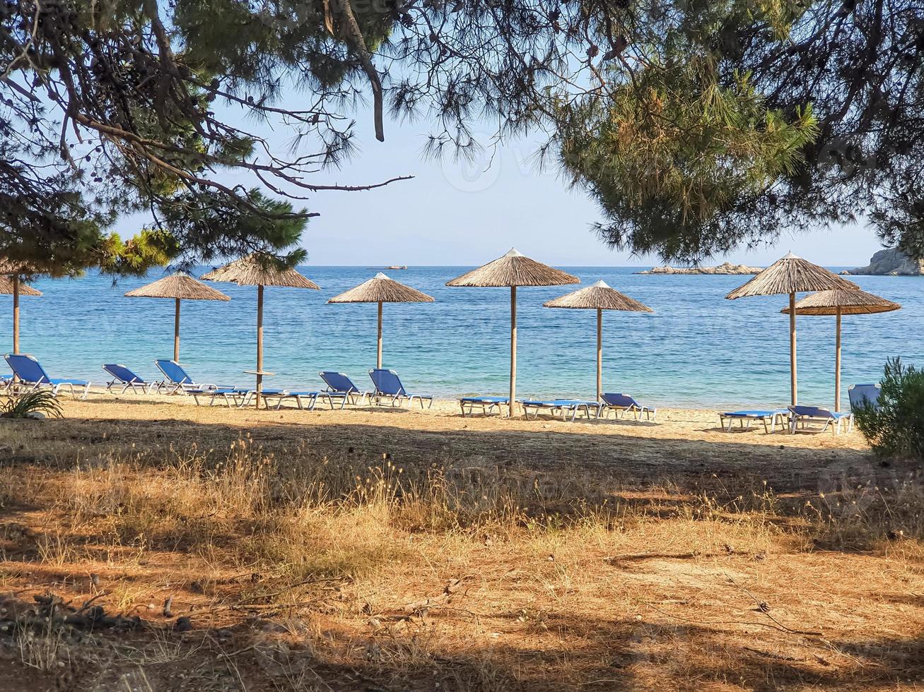 ongerept uitzicht op de baai van een Grieks eiland met lege ligstoelen en parasols.. foto