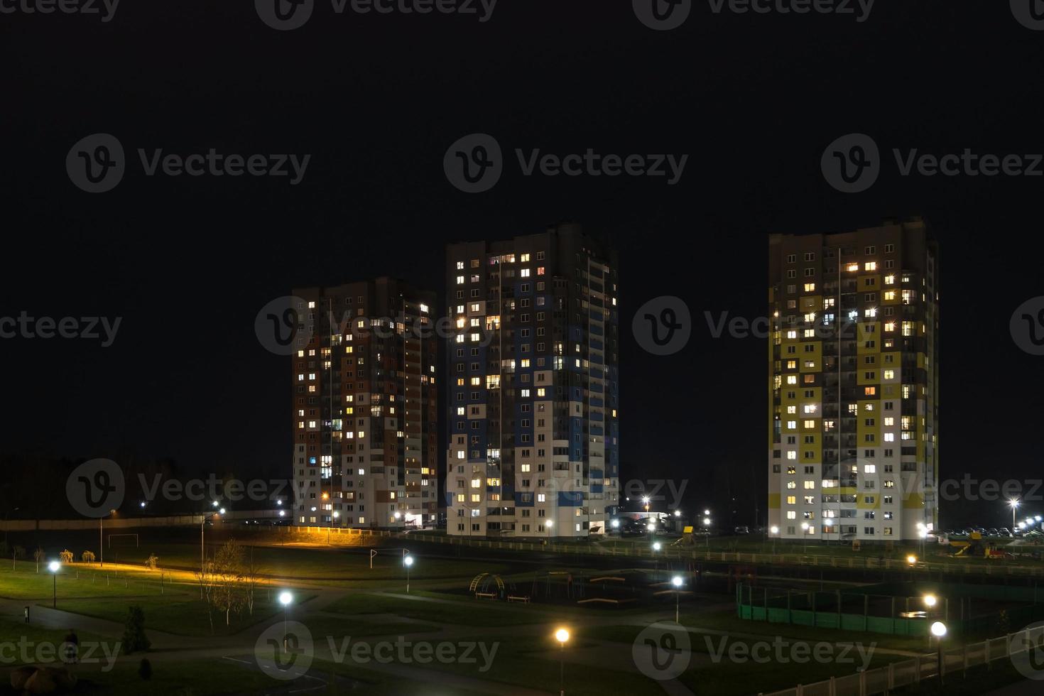 nachtpanorama van licht in de ramen van een gebouw met meerdere verdiepingen. leven in een grote stad foto