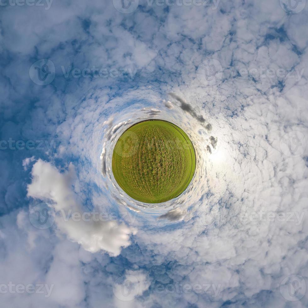 groene kleine planeet in blauwe lucht met prachtige wolken. transformatie van bolvormig panorama 360 graden. sferische abstracte luchtfoto. kromming van de ruimte. foto