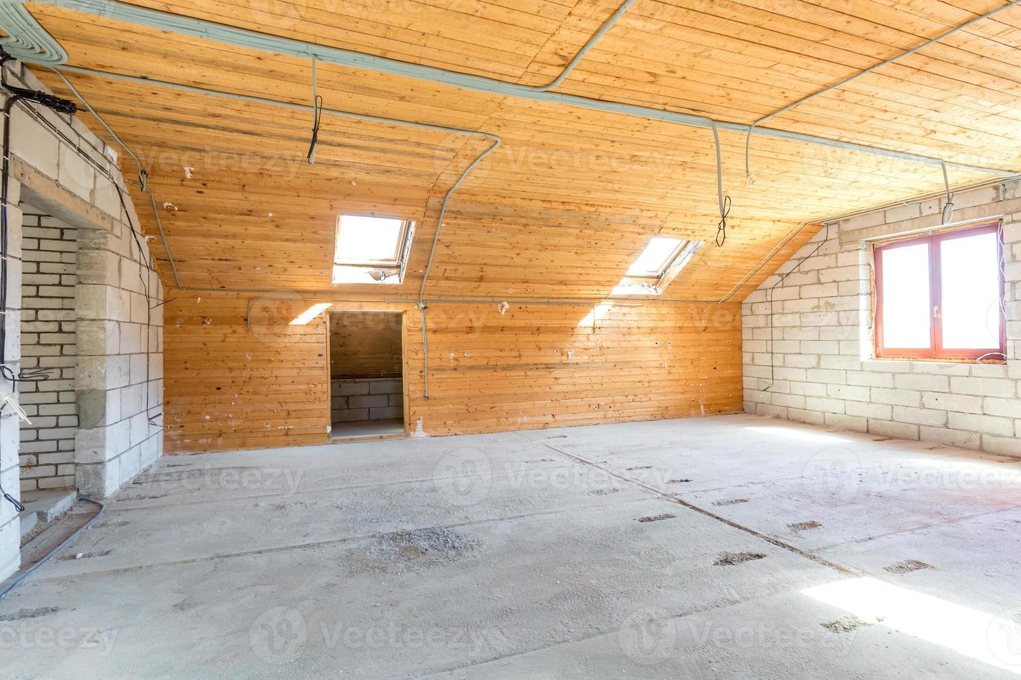 leeg interieur in huis zonder reparatie op houten mansardevloer en bakstenen muur foto