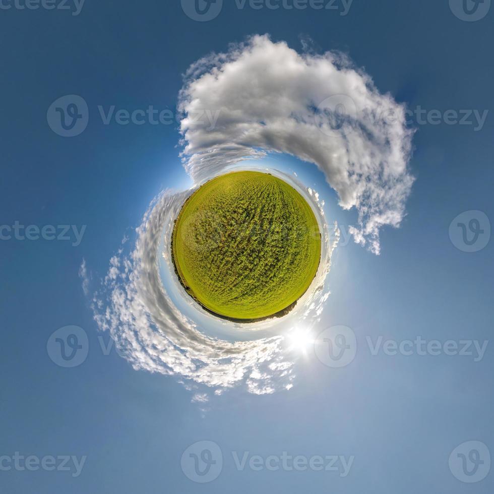 groene kleine planeet in blauwe lucht met zon en prachtige wolken. transformatie van bolvormig panorama 360 graden. sferische abstracte luchtfoto. kromming van de ruimte. foto