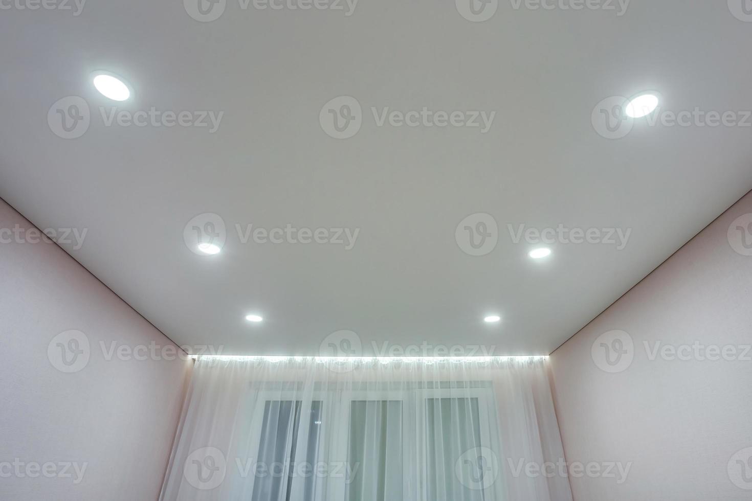 verlaagd plafond met halogeenspots lampen en gipsplaten constructie in lege ruimte in appartement of huis. spanplafond wit en complexe vorm. foto